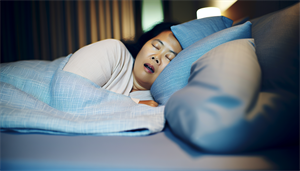 A person sleeping with their mouth open, indicating potential sleep apnea