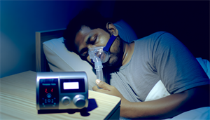 Photo of a person using a CPAP machine for sleep apnea treatment